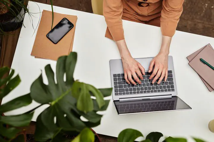 Hands of young businesswoman or student typing on laptop keyboard